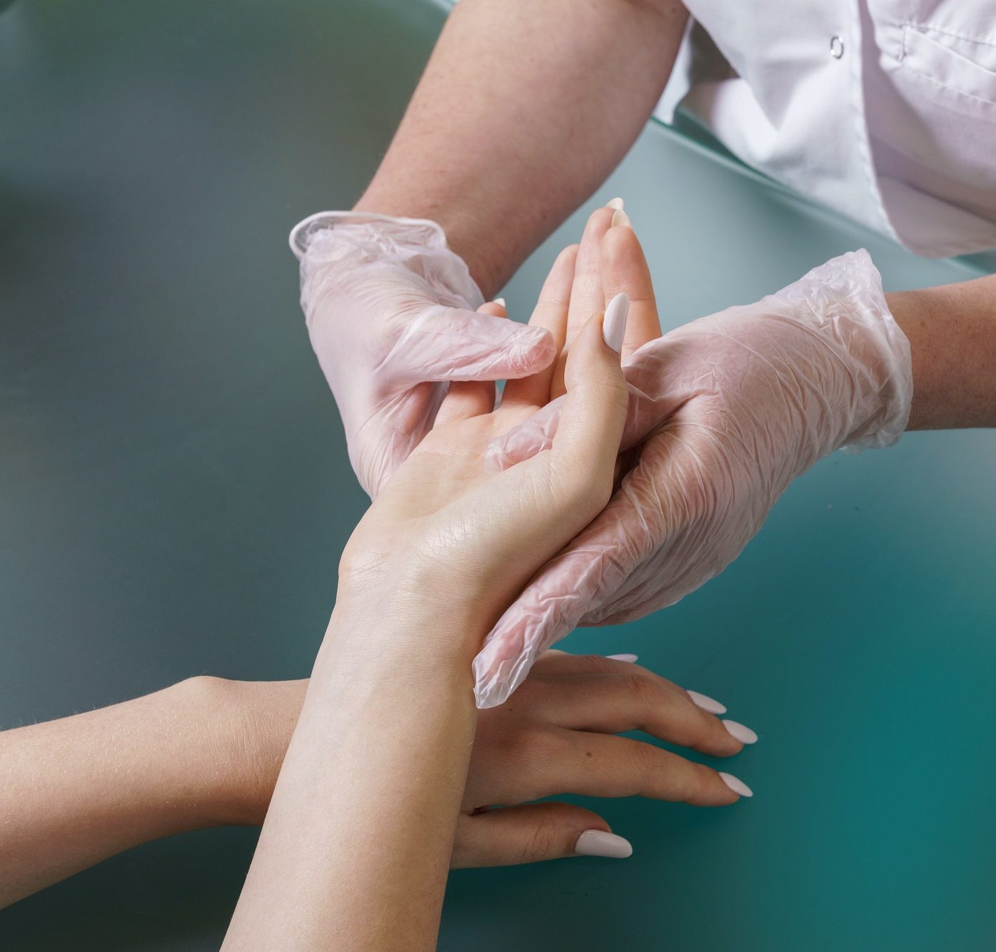 Manicurist does professional light hand massage after manicure procedure.
